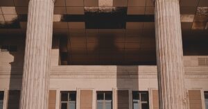 Tall stone columns at the entrance of a courthouse in warm late-afternoon light